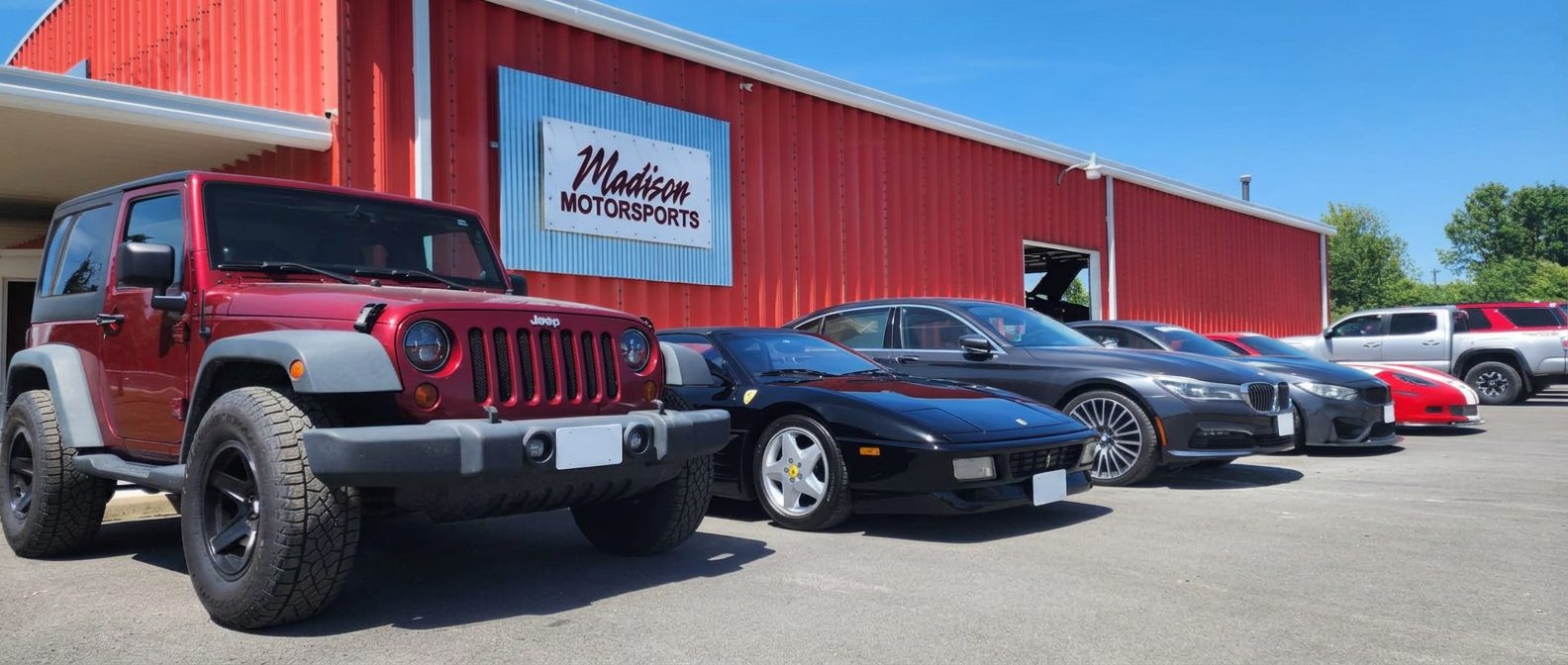 Jeep, Ferrari and BMW parked in front of the Madison Motorsports building