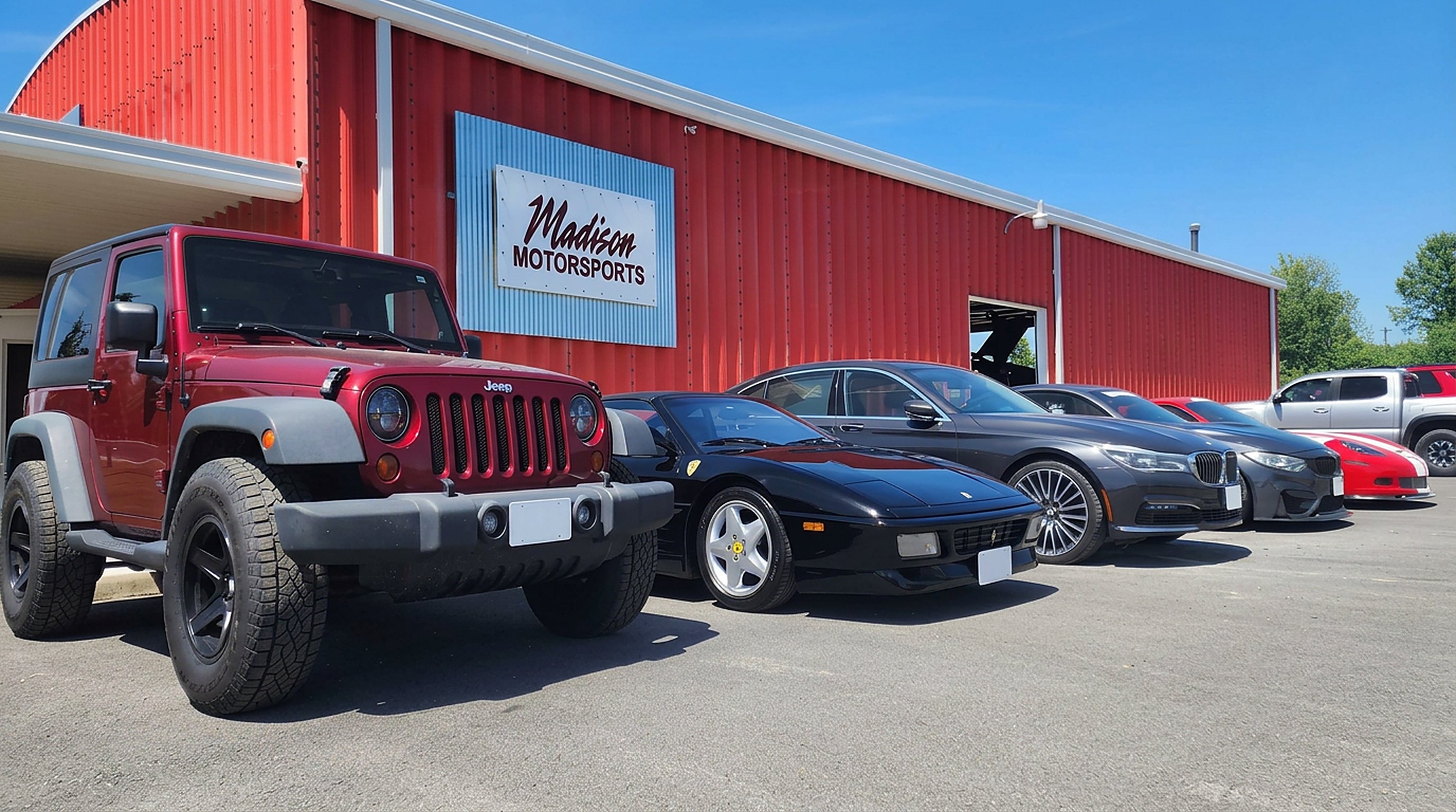 Jeep, Ferrari and BMW parked in front of the Madison Motorsports building