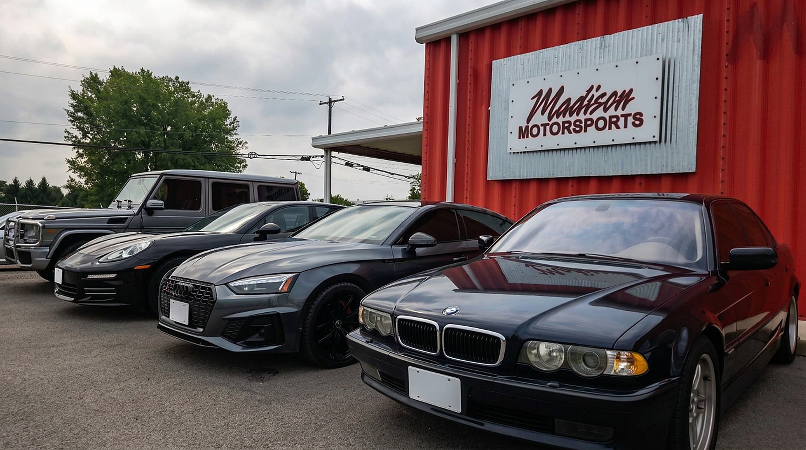 BMW 7 Series, Audi, Porsche Cayenne and Mercedes G-Wagon beside the Madison Motorsports sign